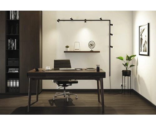 Modernes Arbeitszimmer mit Schreibtisch, Bürostuhl, Regalsystem und Wandleuchte.