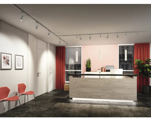 Warteraum mit Empfangstresen, Schienenleuchten und Stühlen