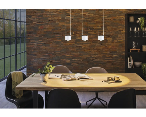 Esszimmer mit Esstisch, Stühlen und drei Pendelleuchten