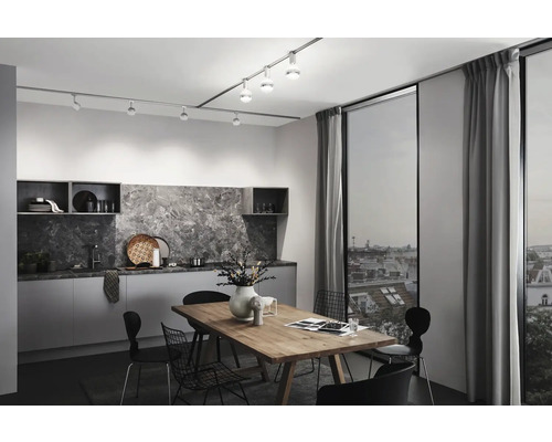 Moderne Küche mit Esstisch, Stühlen und Schienensystem mit Strahlern zur Beleuchtung.