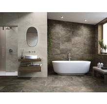 Salle de bains avec douche, lavabo, miroir et baignoire îlot devant un mur carrelé.