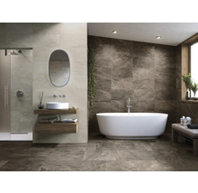 Salle de bains lumineuse avec douche, lavabo et baignoire îlot, ainsi que carrelage mural et au sol aspect pierre naturelle.