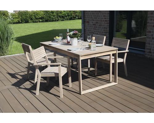 Gartenszene mit Esstisch und vier Stühlen auf einer Terrasse mit Dekoration