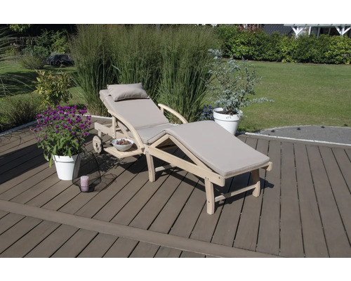 Chaise longue en bois avec coussin et table d''appoint dans le jardin.