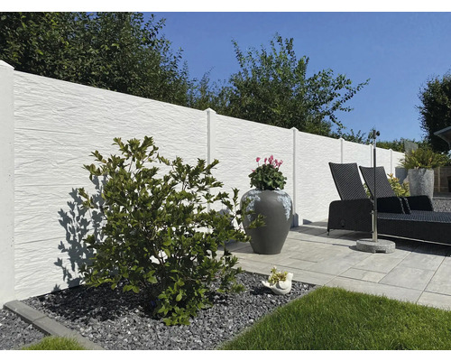 Gartenszene mit Sichtschutzzaun, Liegestuhl und Bepflanzung