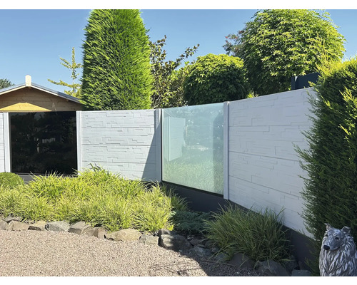 Clôture de jardin avec aspect pierre et éléments en verre devant le jardin