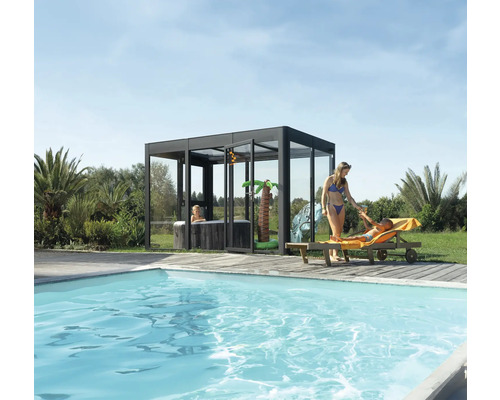 Espace piscine avec piscine, bain à remous dans une construction en verre et personnes se relaxant sur une chaise longue