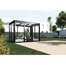 Gewächshaus aus Glas und Metall mit einer Person, die darin Pflanzen pflegt, im Garten