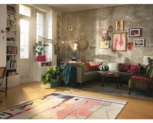 Wohnzimmer mit Sofa, Teppich und Dekorationen für eine Geburtstagsfeier.