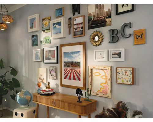 Décoration murale avec une variété d''images et d''éléments décoratifs au-dessus d''une table console