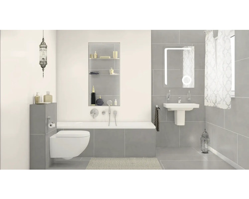 Salle de bain lumineuse avec toilettes, baignoire, lavabo, miroir et décorations