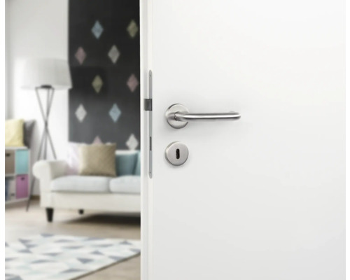 Weiße Tür mit silberner Türklinke und Schlüsselloch in Wohnraum