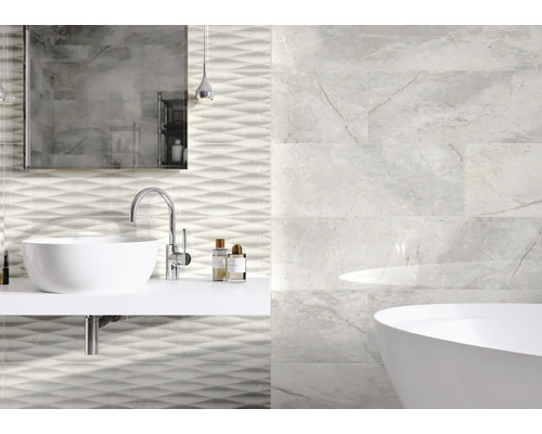 Salle de bain avec lavabo, miroir, baignoire et carrelage mural aspect marbre et motif ondulé