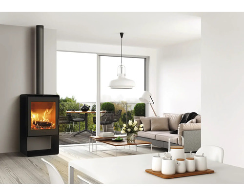 Séjour avec poêle à bois, canapé et table à manger sur le balcon