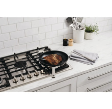 Steak T-bone dans une poêle à frire sur une cuisinière