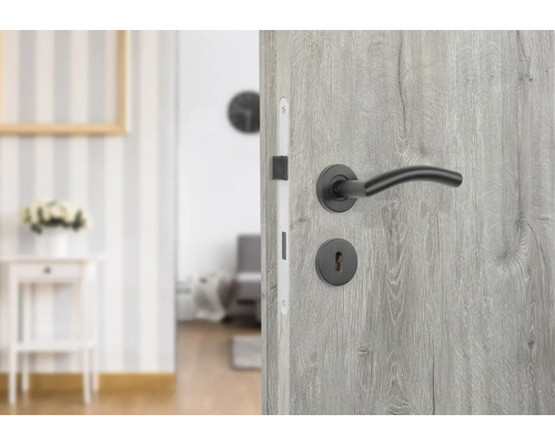 Geöffnete graue Innentür mit schwarzem Türgriff und Schlüsselloch