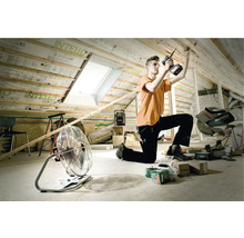 Artisan travaillant à l''aménagement des combles avec des outils tels qu''une perceuse sans fil, un ventilateur et une radio de chantier.
