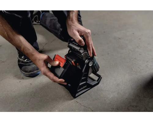 Akku-Baustrahler mit Hand beim Einsetzen des Akkus