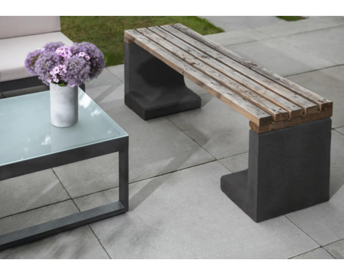 Gartenszene mit Holzsitzbank auf Betonfüßen und einem Tisch mit Glasplatte
