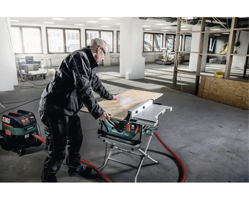 Ein Mann bedient eine Metabo Tischkreissäge in einem Raum im Rohbau.