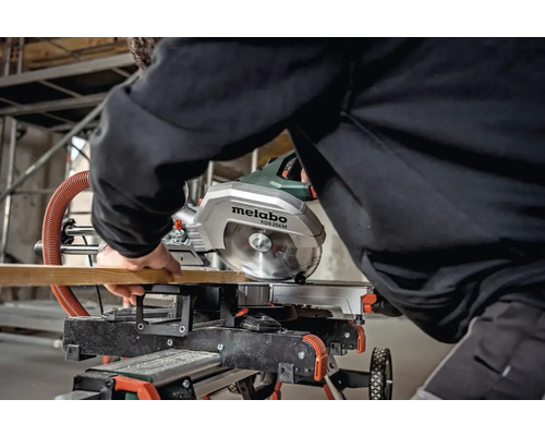 Eine Metabo Kappsäge KGS 254 M schneidet ein Holzbrett.