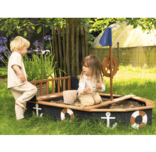 Zwei Kinder spielen in einem Sandkasten in Form eines Bootes im Garten.