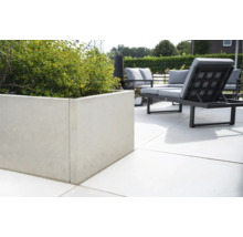 Beton-Pflanzgefäß mit Bepflanzung auf einer Terrasse mit Gartenmöbeln