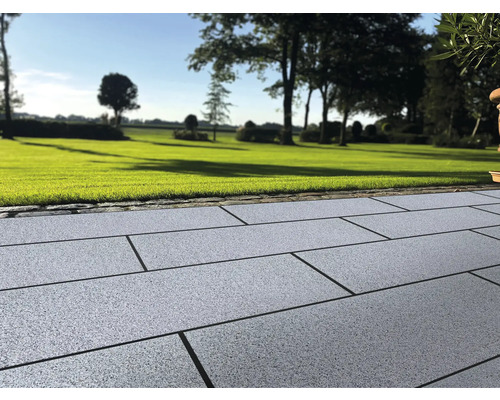 Aussenbereich mit Pflastersteinen und Rasenfläche