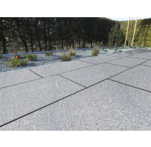 Terrasse avec dalles de pierre grises et parterre de gravier avec plantes