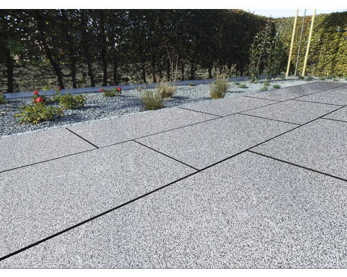 Terrasse avec dalles de pierre grises et parterre de gravier avec plantes