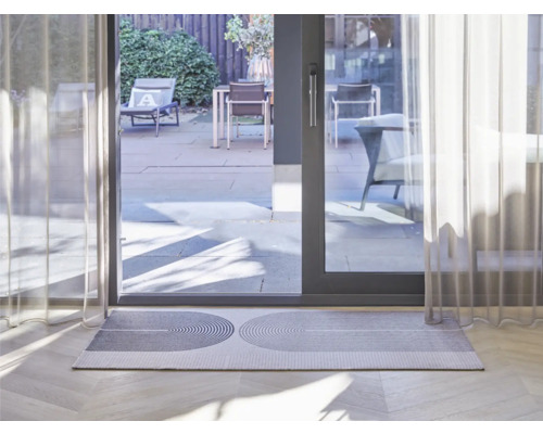 Paillasson à motif géométrique devant une porte de terrasse