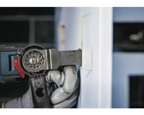 Outil multifonction en cours d''utilisation pour couper un matériau