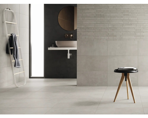 Helles Badezimmer mit Fliesen, Waschbecken und Leiterregal für Handtücher