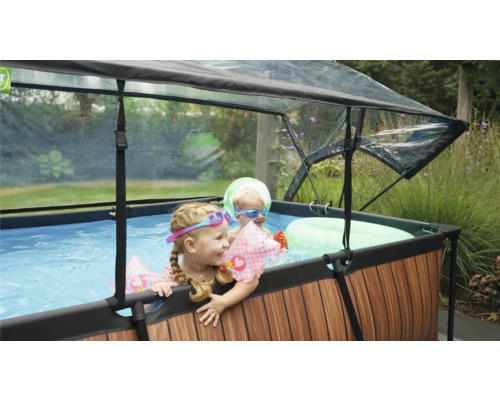 Piscine hors sol avec toit et enfants jouant dans le jardin