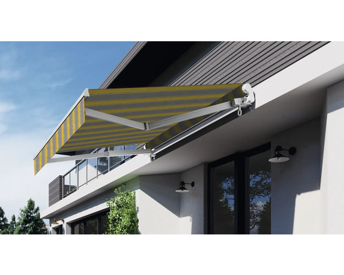 Store banne à bras articulé déployé avec un tissu de store rayé sur la maison