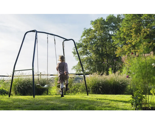 Kind auf einer Gartenschaukel im Garten