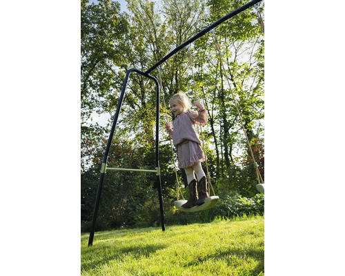 Mädchen schwingt auf einer Schaukel im Garten.