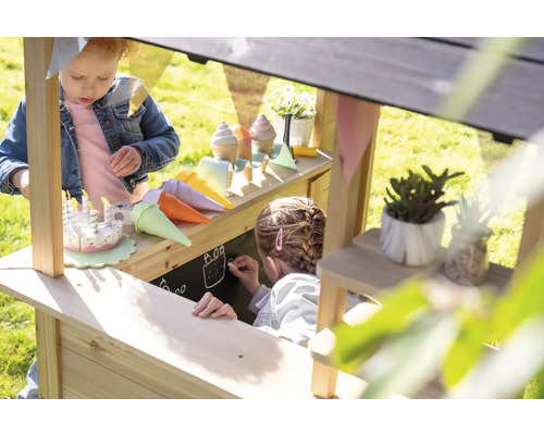 Des enfants jouent dans une épicerie en bois avec tableau noir, glace et gâteau