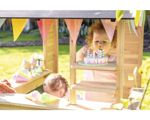 Des enfants jouent dans un magasin en bois avec des aliments jouets et une guirlande.