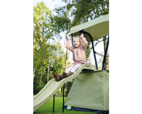 Mädchen rutscht auf einer Spielplatzrutsche in einem Garten