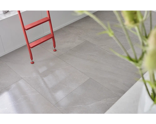 Heller Raum mit Bodenfliesen in Steinoptik und roter Leiter