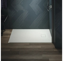 Salle de bains avec receveur de douche plat sur plancher en bois devant un mur à motifs