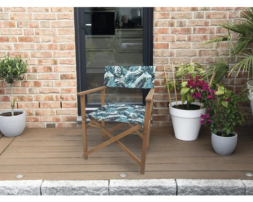 Regiestuhl mit Blattmuster vor einer Ziegelwand