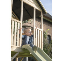 Garçon sur une tour de jeu en bois avec toboggan dans le jardin