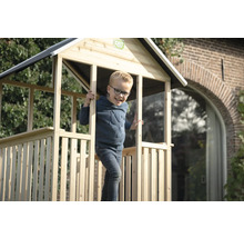 Enfant dans une cabane en bois dans le jardin