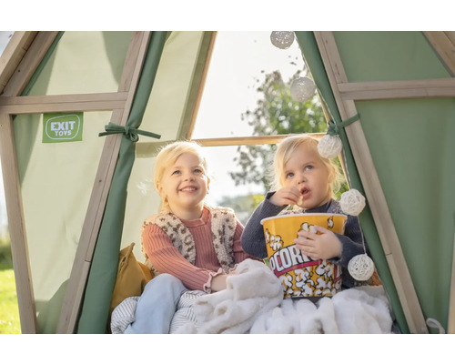Zwei Kinder sitzen in einem Spielzelt und essen Popcorn. EXIT Toys Logo ist sichtbar.