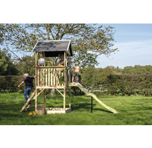 Tour de jeu en bois avec toboggan dans le jardin avec des enfants qui jouent