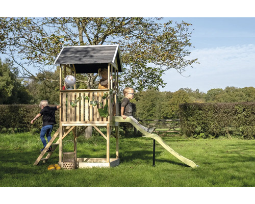 Tour de jeu en bois avec toboggan dans le jardin avec des enfants qui jouent