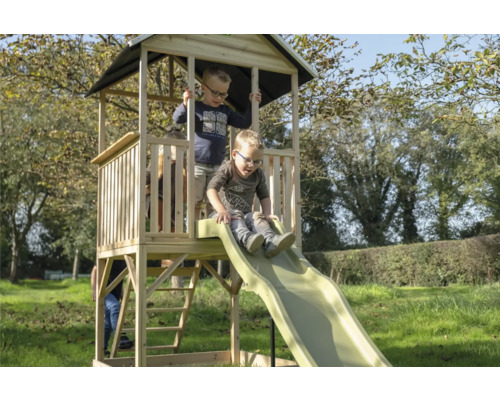 Aire de jeux avec toboggan dans le jardin avec des enfants qui jouent.