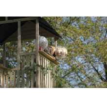 Enfant regardant depuis une cabane en bois avec décoration